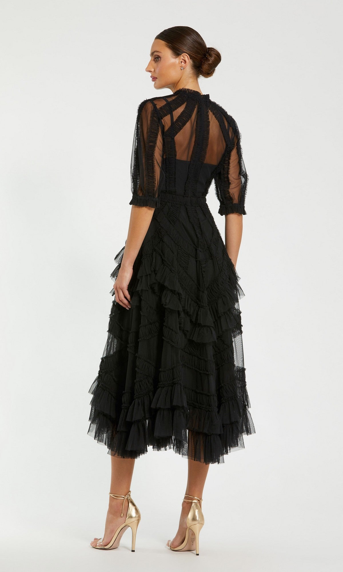 Woman in profile wears the Mac Duggal 8058 Ruffled Midi Wedding-Guest Dress, styled with ruffled sleeves, sheer accents, a fitted bodice, and metallic high-heeled sandals.